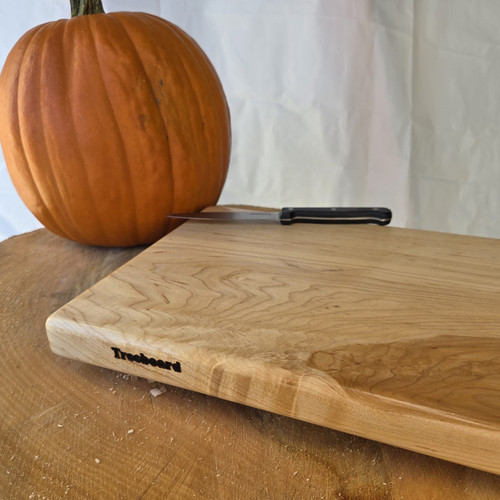 Medium hard maple cutting board by Treeboard with a pumpkin and knife on a sycamore stump. Medium hard maple cutting board by Treeboard with a pumpkin and knife on a sycamore stump.