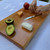 Large black cherry serving board and cutting board or cheese board by Treeboard with goat cheese, or chevre, avocado, hands.
