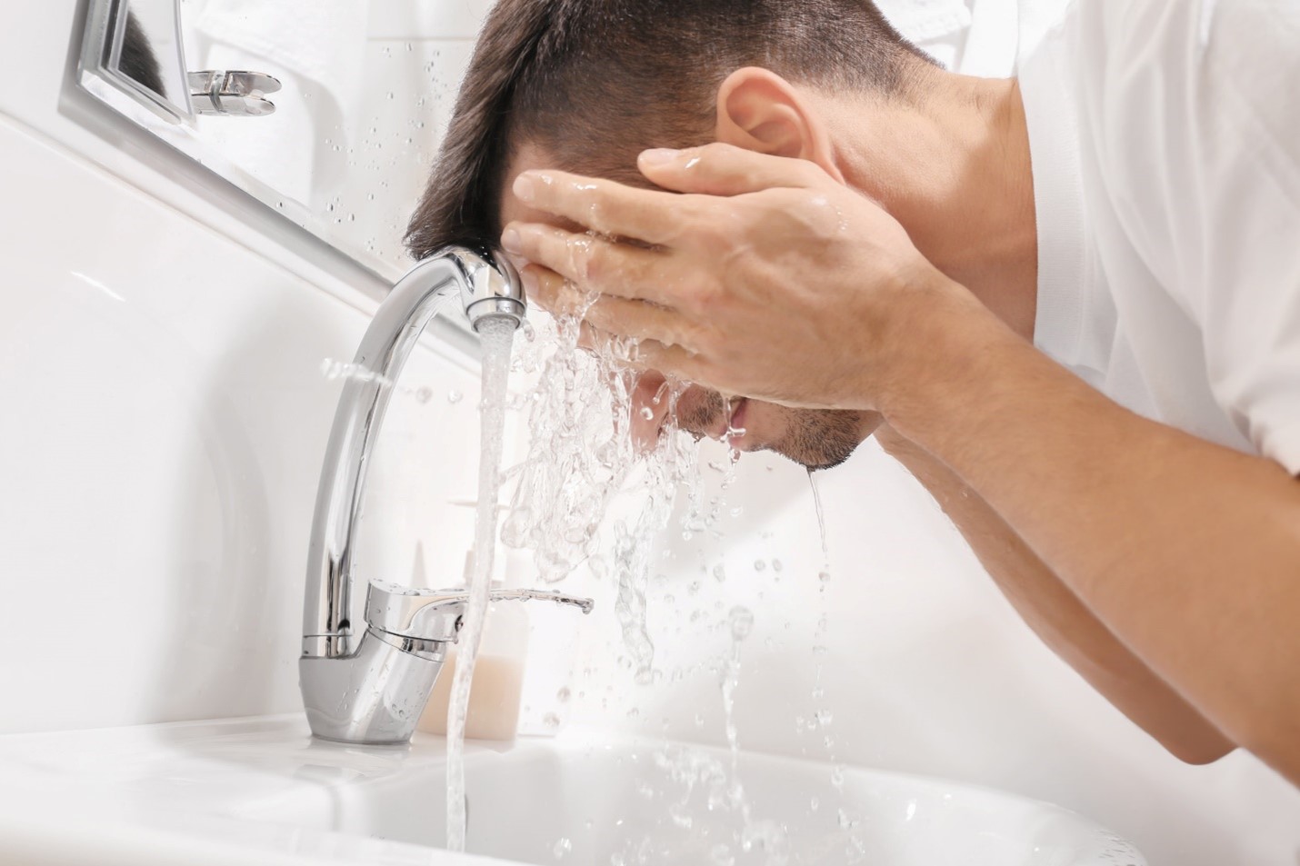 A person washing his hands in the sink Description automatically generated with low confidence