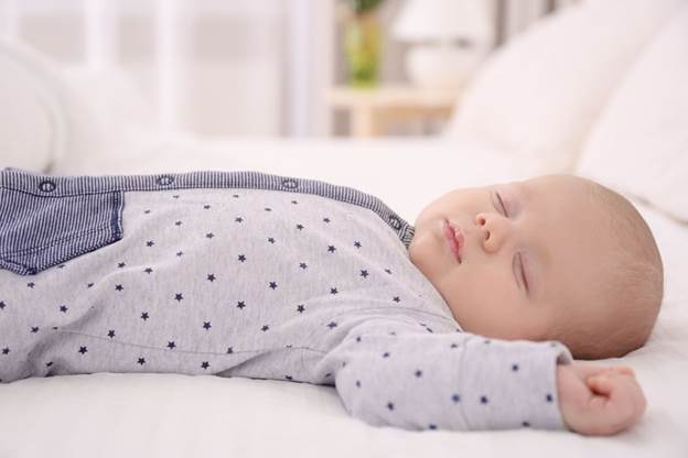 A baby lying on a bed