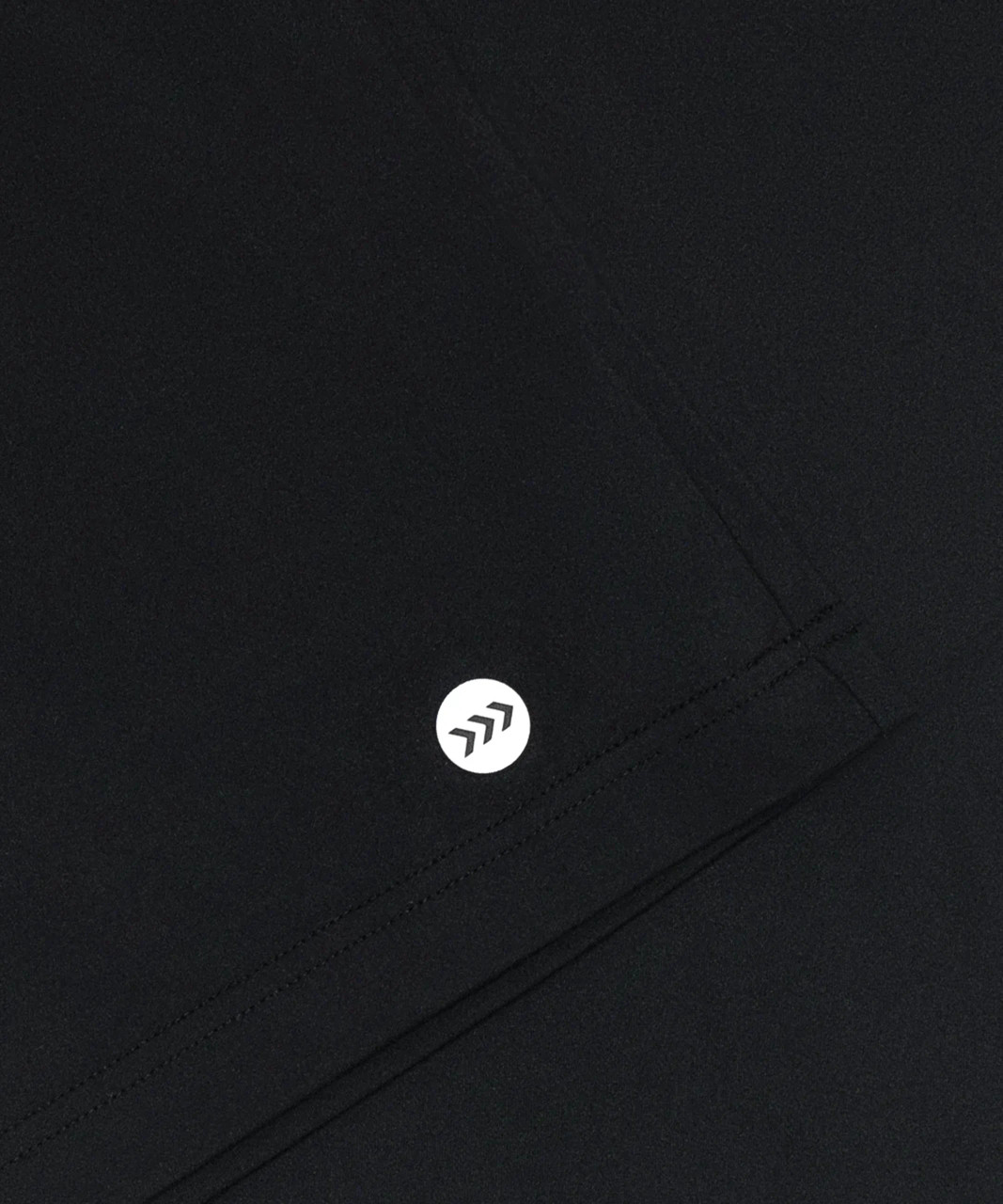 Core MB Polo, black performance polo with silicone Bomber hip logo, close-up view