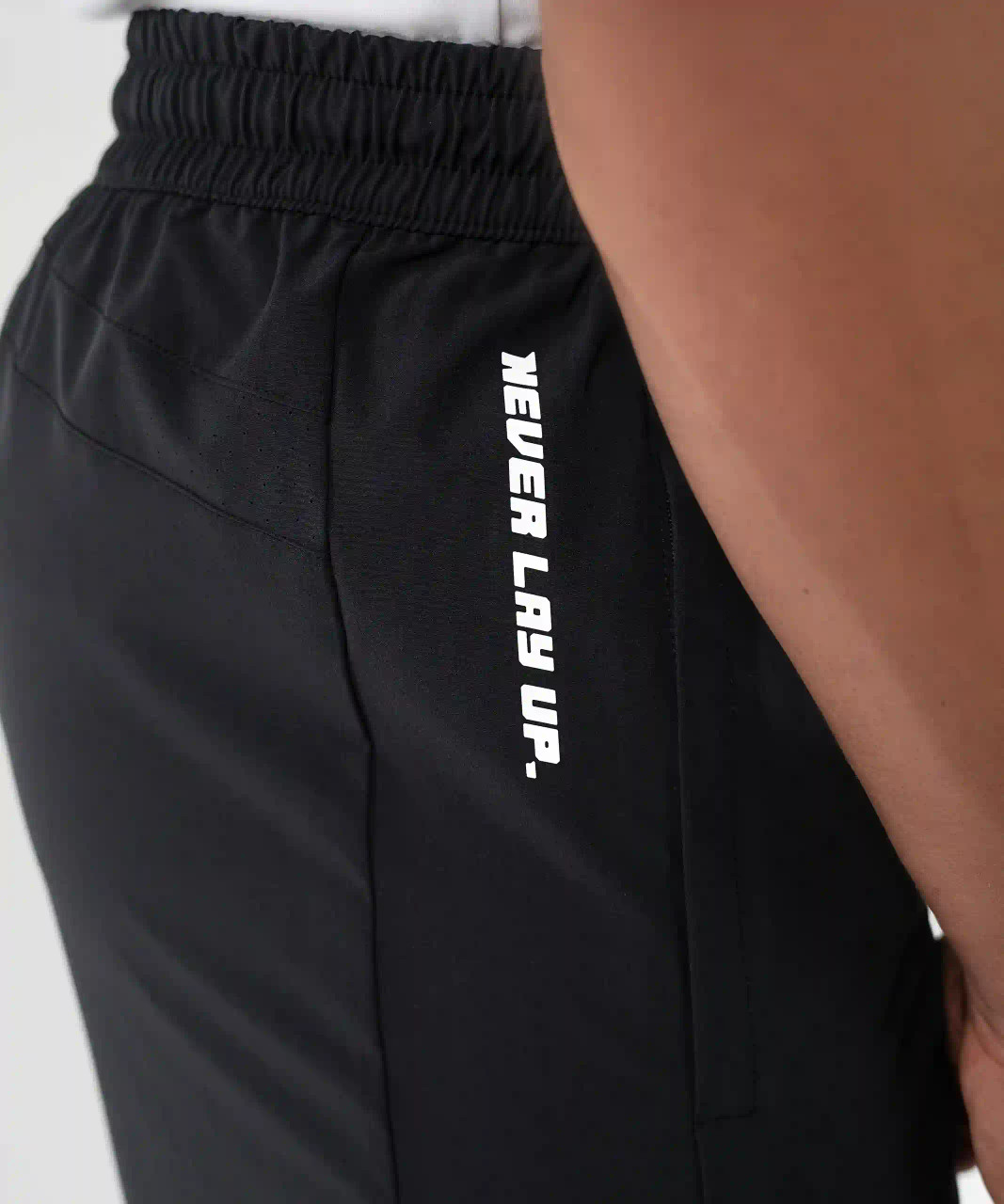 Focus Active Short, men's black athletic shorts with deep hand pocket and heat transfer logo, close-up view