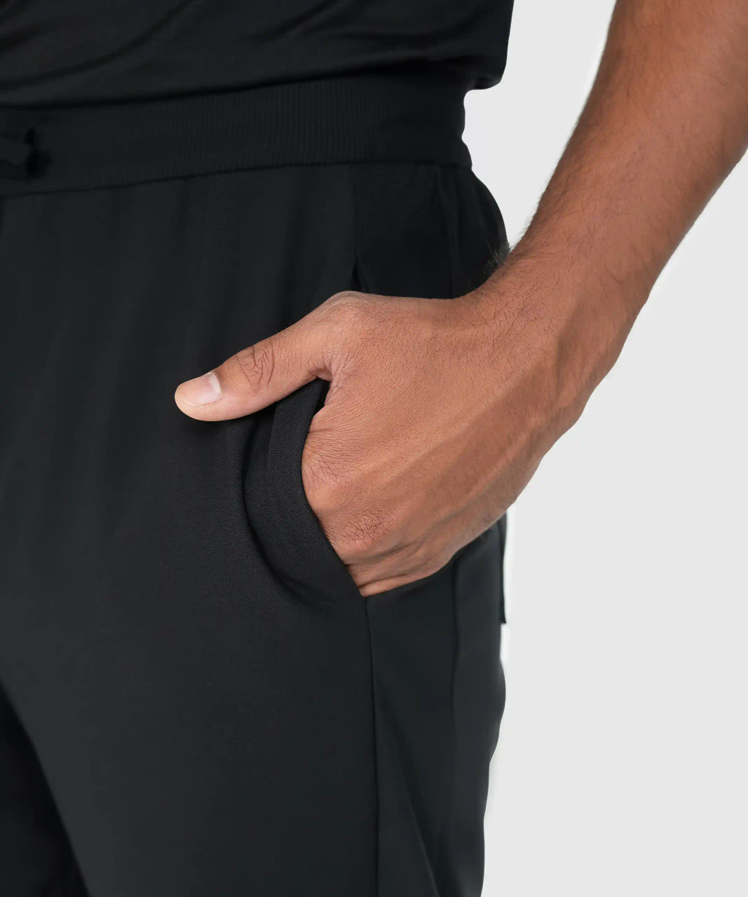 Triumph Jogger, men's black athletic jogger with deep hand pocket and silicone logo, close-up view