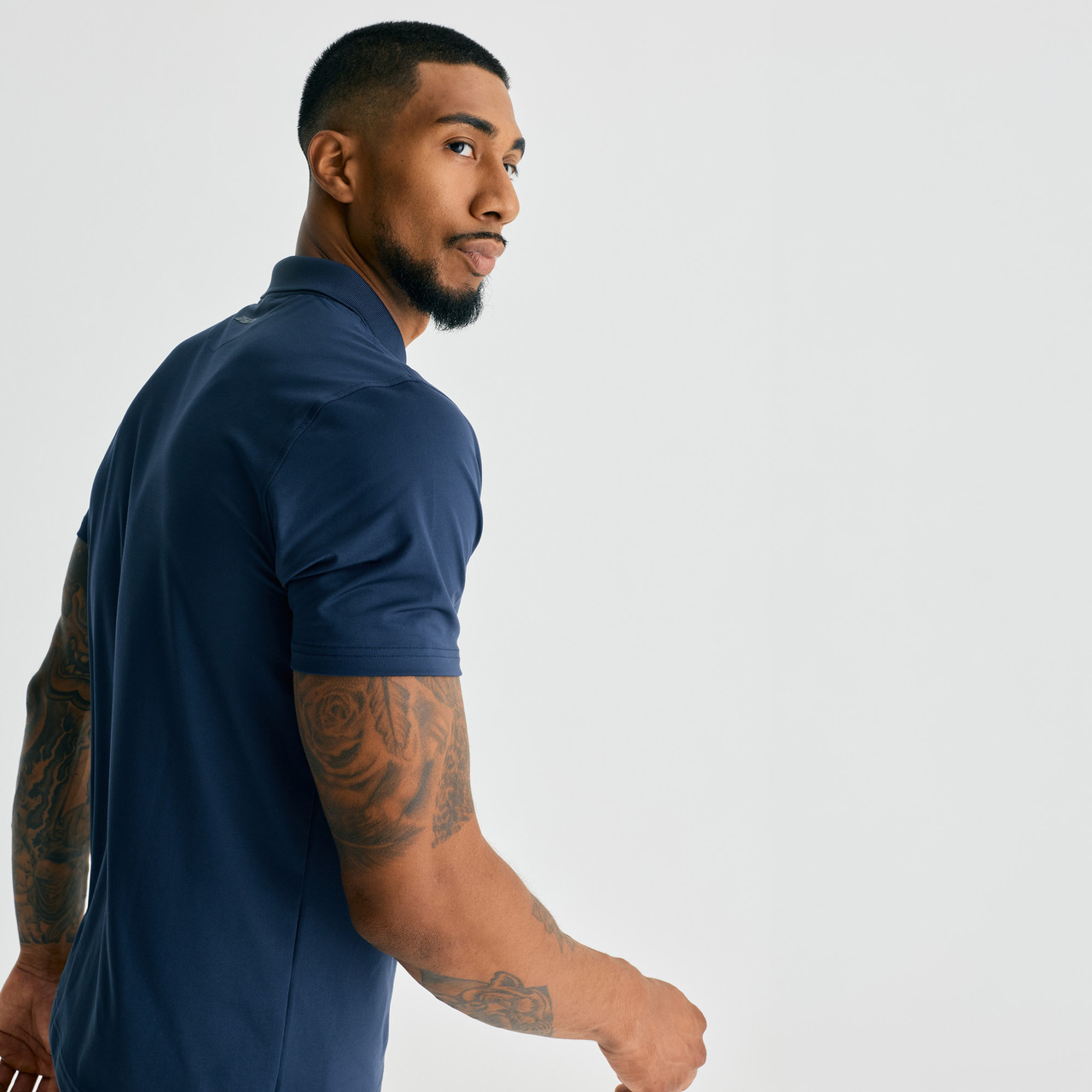 Legacy T-Polo, men's performance navy polo shirt, side walking view