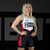 Photo of a college female athlete wearing Combat Corner’s premium Classic Combat Corner Wrestling Singlet. The woman is standing in Combat Corner’s collegiate wrestling training gym. She is standing and facing the camera before her wrestling training session. This Classic Combat Corner Singlet gives you champion performance in Folkstyle, Freestyle, and Greco-Roman wrestling. Plus, this singlet serves all wrestling athletes. This singlet is designed for kids to adults and for men and women.
