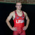 Wrestler standing with arms at his sides in red singlet