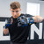A model in a black t-shirt posing in a fighting stance while wearing the Combat Corner Blue Ammy MMA Tech 6oz. Fight Glove.