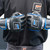 A close-up lifestyle shot of a fighter's hands brought together in front of a black t-shirt, wearing a pair of black and red Combat Corner Blue Ammy MMA Tech 6oz. Fight Gloves.