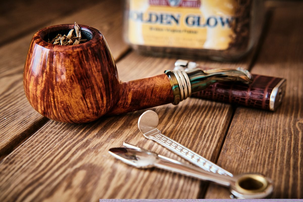 Pipe with tobacco in it and pipe tools on a table