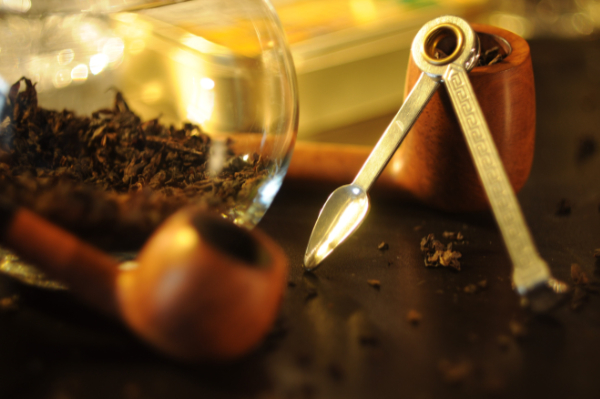 A tamper to push the burning layer of tobacco into proximity with the unburned tobacco below it