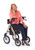 A smiling woman sitting comfortably on the champagne-colored Uno All-Terrain Rollator by Comodita, talking on a cell phone. The image highlights the walker's stable seating, sturdy frame, and large pneumatic wheels against a white background.
