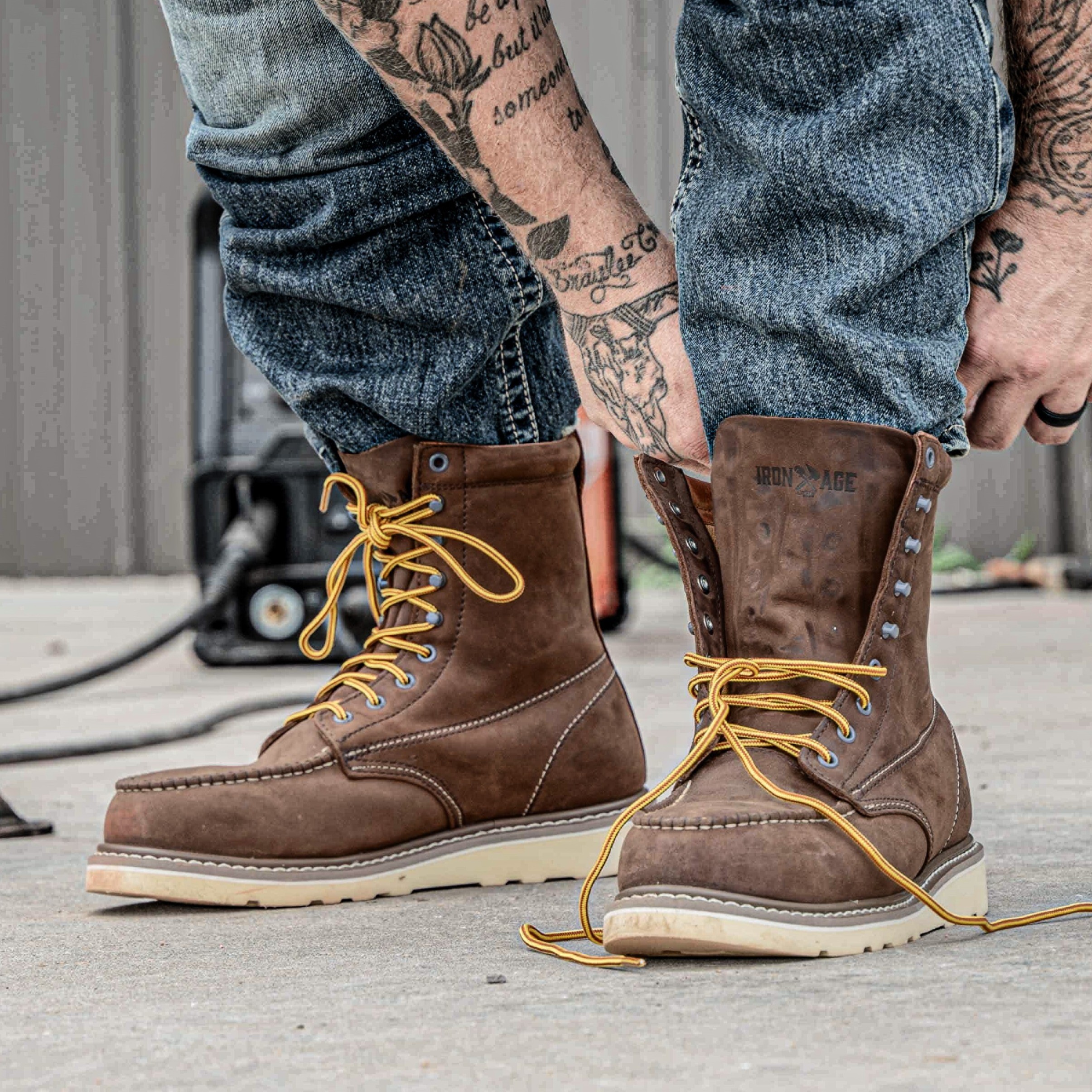 Man lacing up Iron Age 8 Inch Work Boots