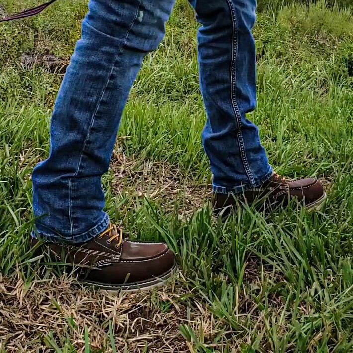 landscaping-boots-square.jpg Groundskeeper wearing a pair of rugged brown Iron Age landscaping work boots standing on grass and dirt, showing they’re built for tough yard work.