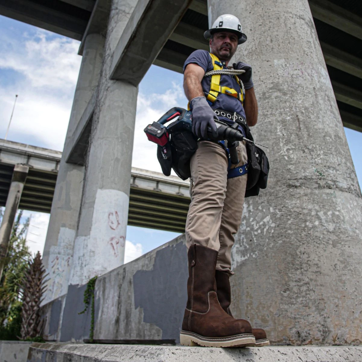 Utility worker wearing pair of rugged Iron Age utility work boots on a jobsite.