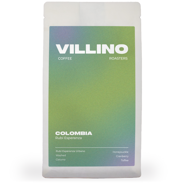 A white bag of single origin coffee with a green and blue label. The white letters at the top of the label reads "Villino Coffee Roasters",  and the small white text at the bottom reads "Colombia Rubí Esperanza".