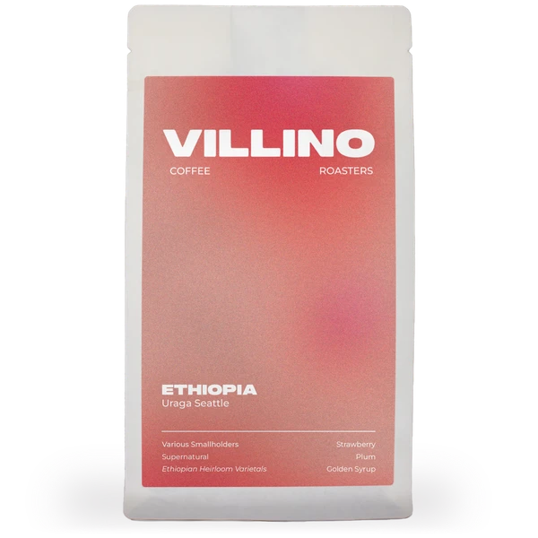 A white bag of single origin coffee with a earthy pink and red label. The white letters at the top of the label reads "Villino Coffee Roasters",  and the small white text at the bottom reads "Ethiopia Uraga Seattle".