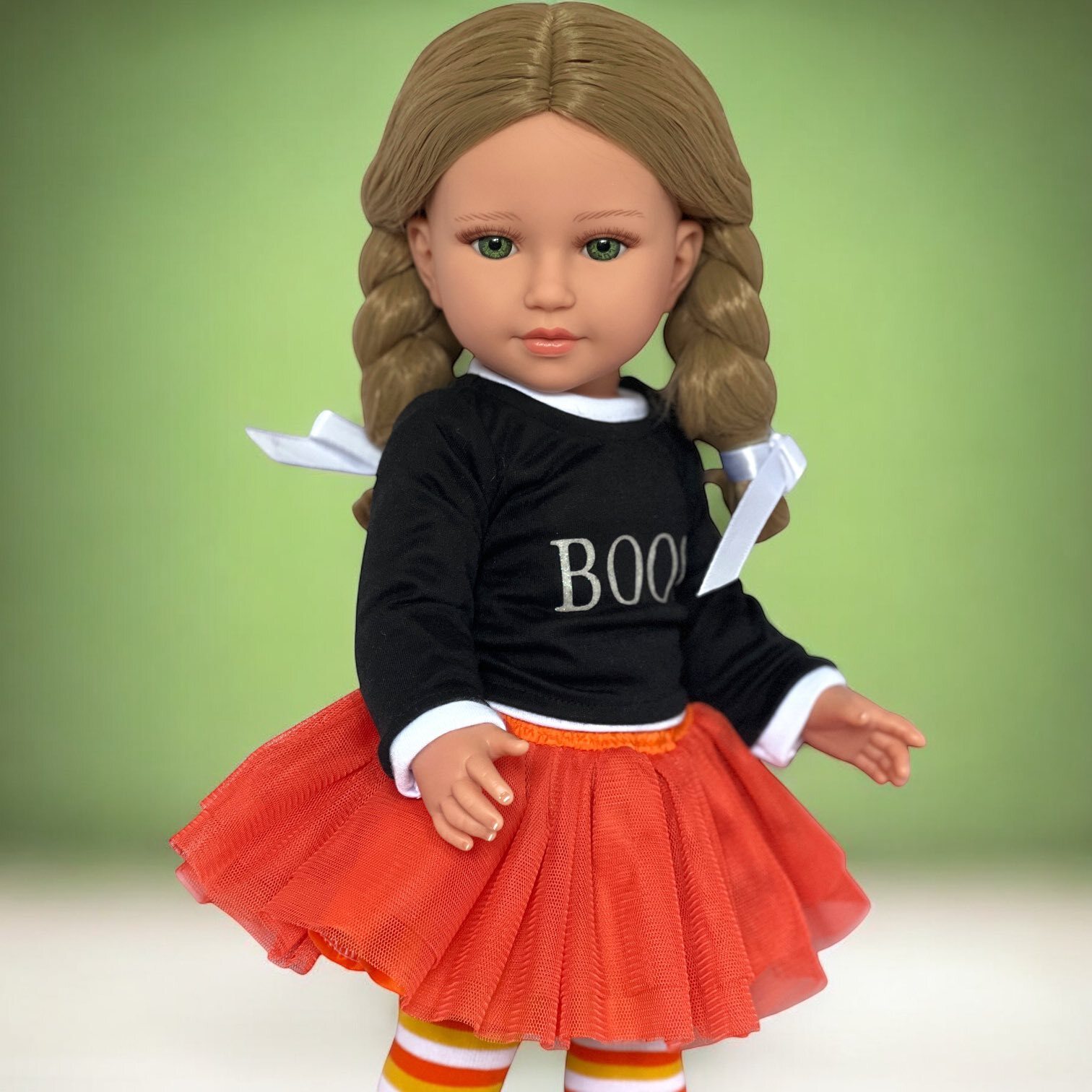 My Brittany’s Halloween outfit on an 18-inch doll featuring a black “BOO!” shirt, orange tutu, striped tights, and black shoes – fits Kennedy and Friends dolls.