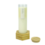 Jumbo glass tube scented candle in a clear glass cylinder, in a hexagonal  bamboo stand with a matching lid beside it.