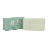 Wholesale plastic-free Geranium, Sweet Orange, Lavender & Ylang Ylang scented laundry soap bar, shown next to it's plastic-free packaging featuring an illustration of clothes on a washing line.