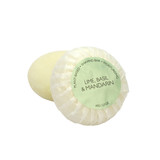 A round bar of Heaven Scent Heritage natural origin shaving soap, pleat wrapped in white paper. The top features a pale green circular label for the Lime, Basil & Mandarin scent.  Made in the UK using sustainable plant-based ingredients.
