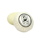 Heaven Scent Lavender, Cananga, Patchouli & Cedar natural origin shaving soap. The round, plant-based soap is shown wrapped in traditional pleat paper, sealed with a circular label featuring a black and white Sarah Pettitt illustration of a man.