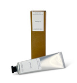 A 60ml tube of Unique cocoa & shea butter hand cream with a Heaven Scent Classic Brading label, standing next to its eco-friendly brown card packaging.