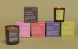 Heaven Scent Bright Collection natural soy and plant wax scented Christmas candle in a brown glass jar displayed beside its matching herb green presentation box against a green botanical background