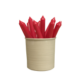 A pack of 16 bulk 10-inch UK-made straight dinner candles in ruby red, arranged in a neutral cream stoneware pot isolated against a clean white background.