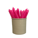 A pack of 16 bulk 10-inch UK-made straight dinner candles in neon dayglow pink, arranged in a neutral cream stoneware pot isolated against a clean white background.