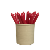 A pack of 16 bulk 10-inch UK-made straight dinner candles in ruby red, arranged in a neutral cream stoneware pot isolated against a clean white background.