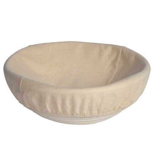 The Now Designs Round Cotton Banneton Basket Liner in a banneton basket with a white background