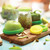 Food Huggers in Fresh Greens filled with fruit and veggies and covering a jar on a table