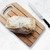Bee's Wrap Bread Wrap wrapped around a loaf of bread on a cutting board.