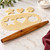 An Ironwood French rolling pin on a kitchen counter with cookie dough.