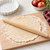 A Fox Run Tapered Rolling Pin on a light wooden cutting board with pie dough.