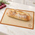 The Mrs. Anderson's Baking bread crisping mat on a kitchen island with a loaf of bread.