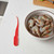 An overhead view of the Harold Import Company shrimp deveiner on a kitchen counter with a bowl of raw shrimp