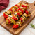 Cooked chicken and veggies on bamboo skewers.