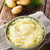 A bowl of mashed potatoes on a wood table