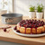 A Mrs Andersons Baking Nonstick Springform Pan by a cherry cheesecake on a kitchen counter