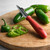 A RSVP International Jalapeno Corer on a cutting board with jalapenos