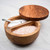The RSVP Olive Wood Salt Box with Swivel lid with salt on a kitchen counter