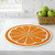 A Wet-It! Orange Round Swedish Cloth on a kitchen counter