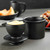 A classic black matte Butter Bell Crock with the lid off and filled with butter