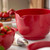A close-up of a luna red Rosti Margrethe mixing bowl on a kitchen counter with strawberries