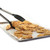 The Norpro Grip-EZ locking spatula tongs open scooping waffle fries from a sheet pan