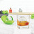 A clear sphere of ice in a glass on a kitchen counter along with one of the Tovolo Sphere Clear Ice System molds.