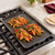 The Nordic Ware Two-Burner Griddle King with peppers, onions, and chicken for fajitas.