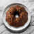 A cake baked in a Nordic Ware Harvest Leaves Bundt Pan on a platter on a marble counter