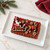 A decorated cake made in the Nordic Ware Santa's Sleigh Loaf Pan on a white platter.